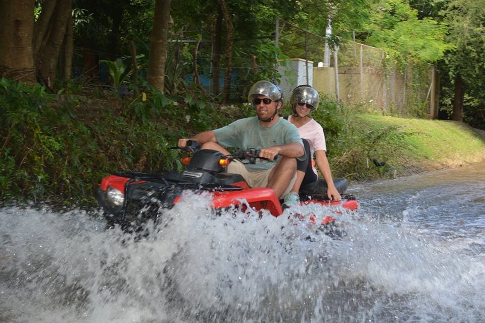 "Adventurers enjoying an ATV ride through lush trails and zip-lining through the canopy in Tamarindo, with scenic jungle views and the ocean in the distance."