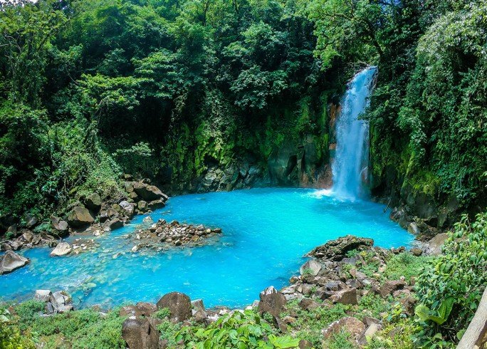 "Stunning turquoise waters of Rio Celeste, with lush rainforest surrounding the river, showcasing the unique natural beauty of Costa Rica's national park."