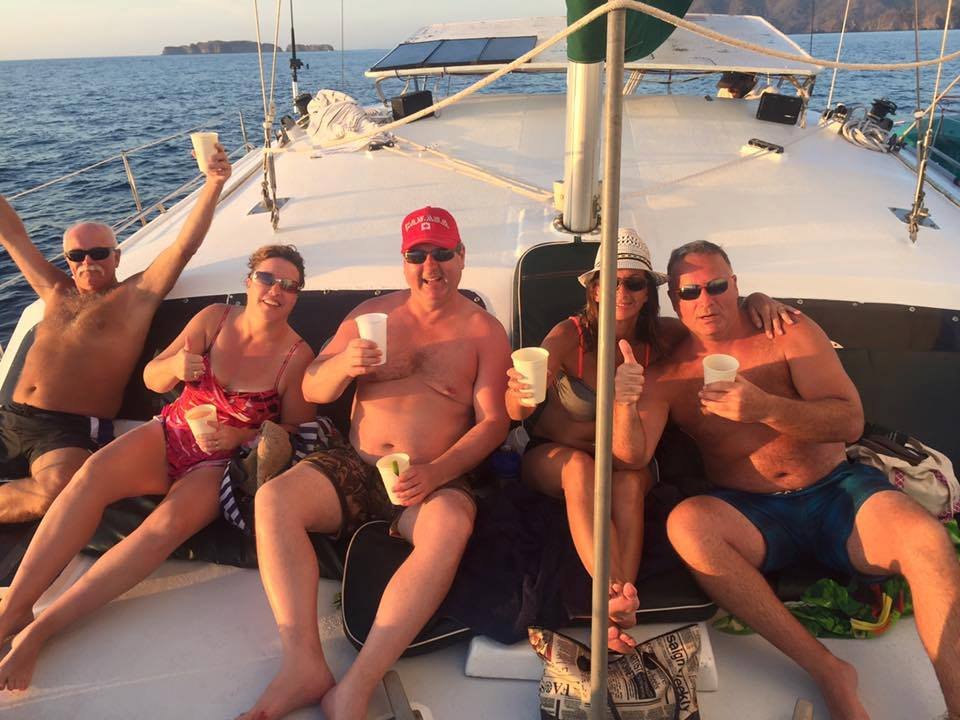 Scenic sailing tour at Flamingo Beach, Costa Rica, with stunning ocean views, a sailboat gliding through calm waters, and a vibrant sunset in the background."