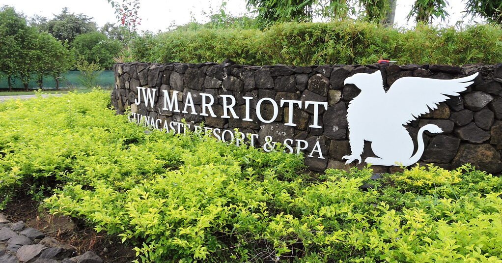 "Scenic drive from Liberia Airport to JW Marriott Guanacaste, passing through lush Costa Rican landscapes with tropical greenery and open roads, heading toward the luxury resort by the Pacific coast."