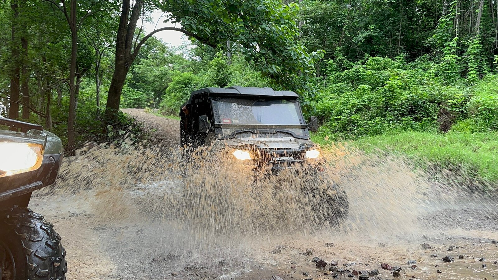 "Group of adventurers riding UTV side-by-side vehicles through the rugged trails of Tamarindo, surrounded by lush jungle and scenic coastal views."